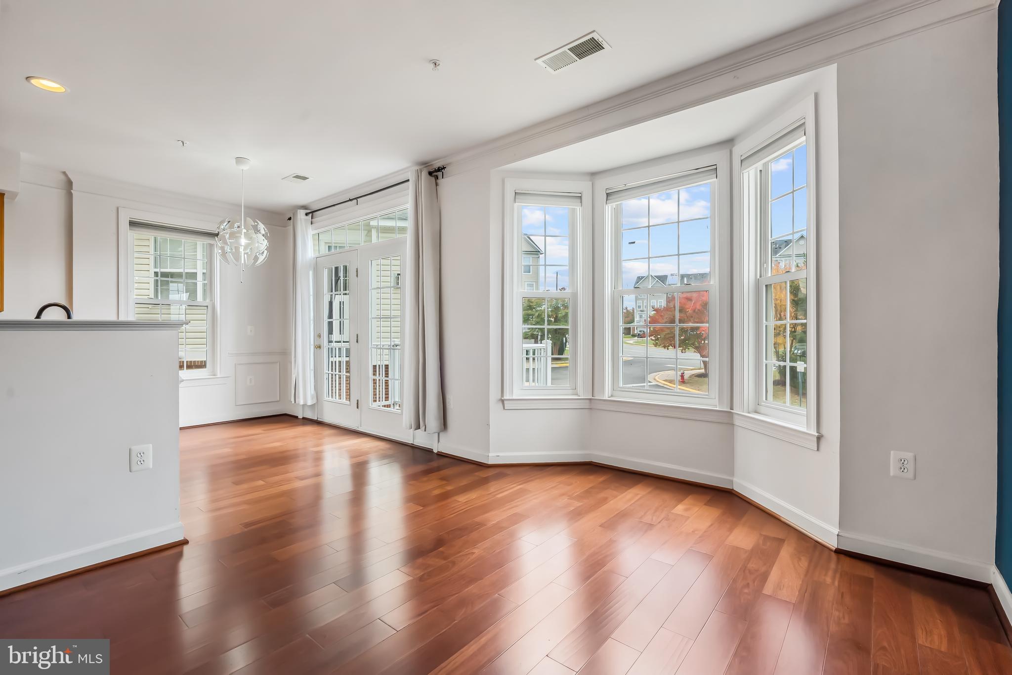 13600 Salk Street, Unit 131 Herndon, VA 20171 - Photo 15 of 34 a view of an empty room with wooden floor and a window