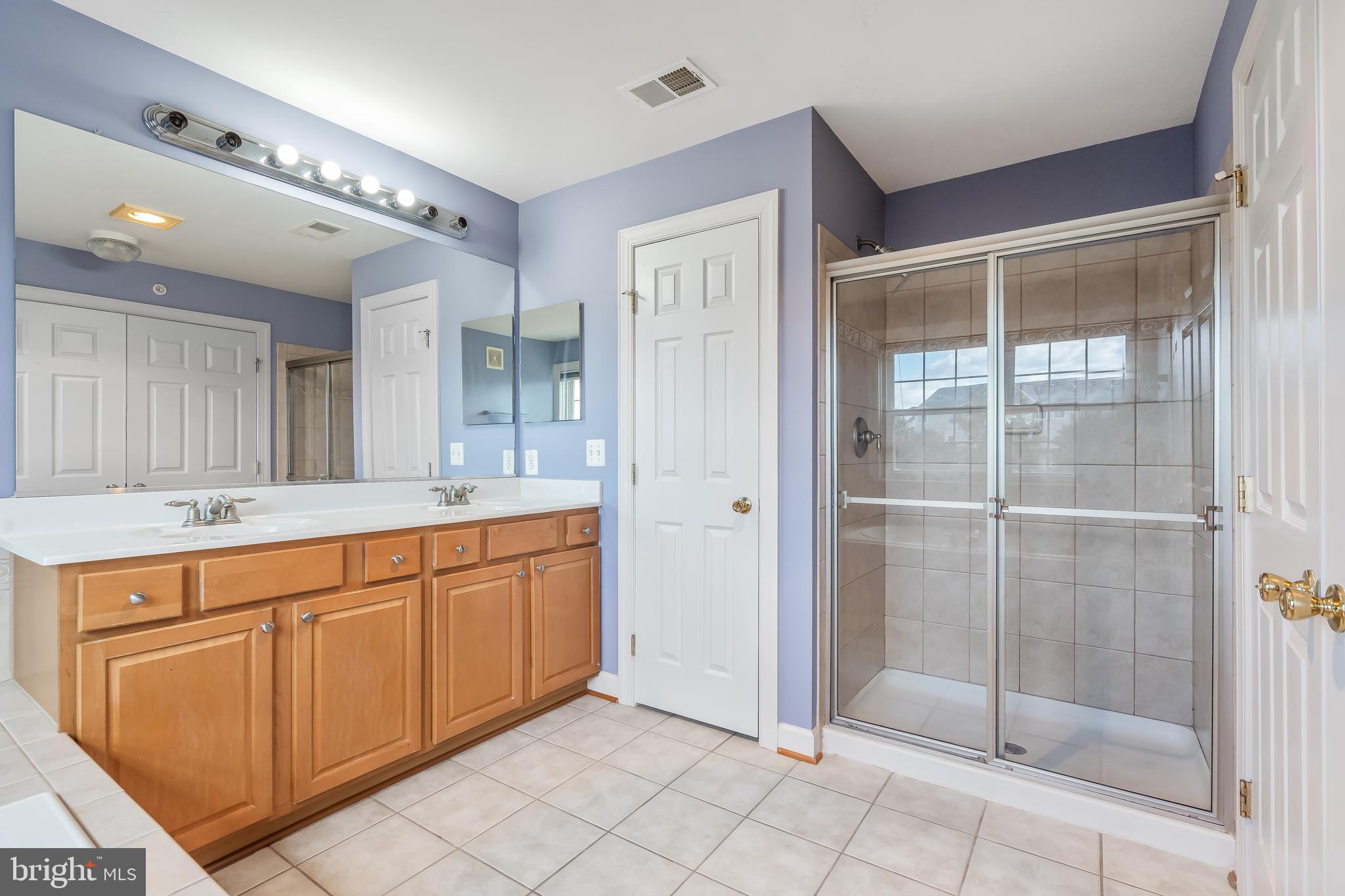 13600 Salk Street, Unit 131 Herndon, VA 20171 - Photo 27 of 34 a spacious bathroom with a shower sink and mirror
