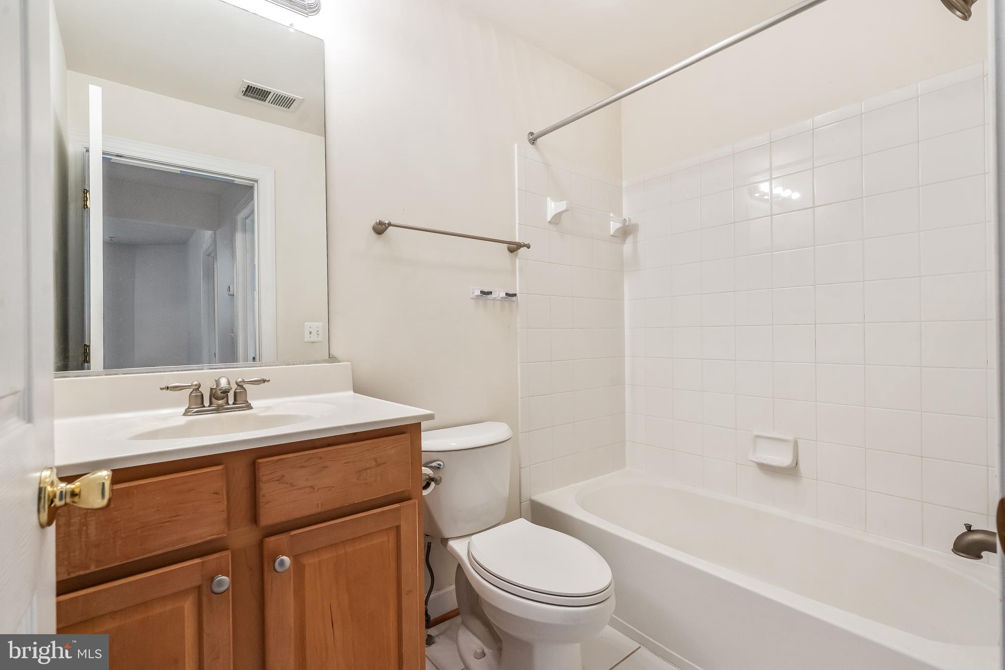 13600 Salk Street, Unit 131 Herndon, VA 20171 - Photo 32 of 34 a bathroom with a sink toilet vanity and shower