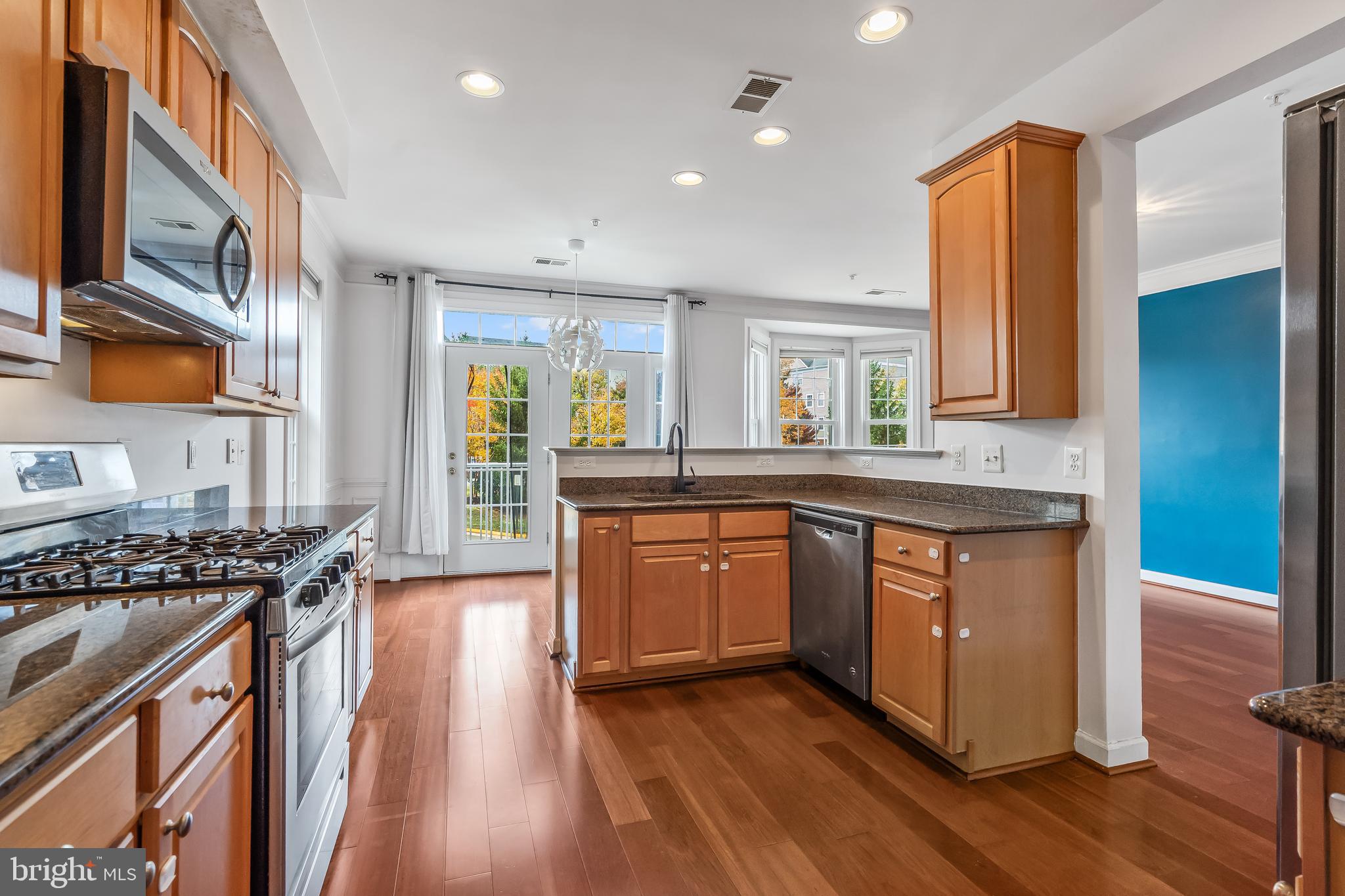 13600 Salk Street, Unit 131 Herndon, VA 20171 - Photo 4 of 34 a kitchen with stainless steel appliances granite countertop a stove a sink and a microwave