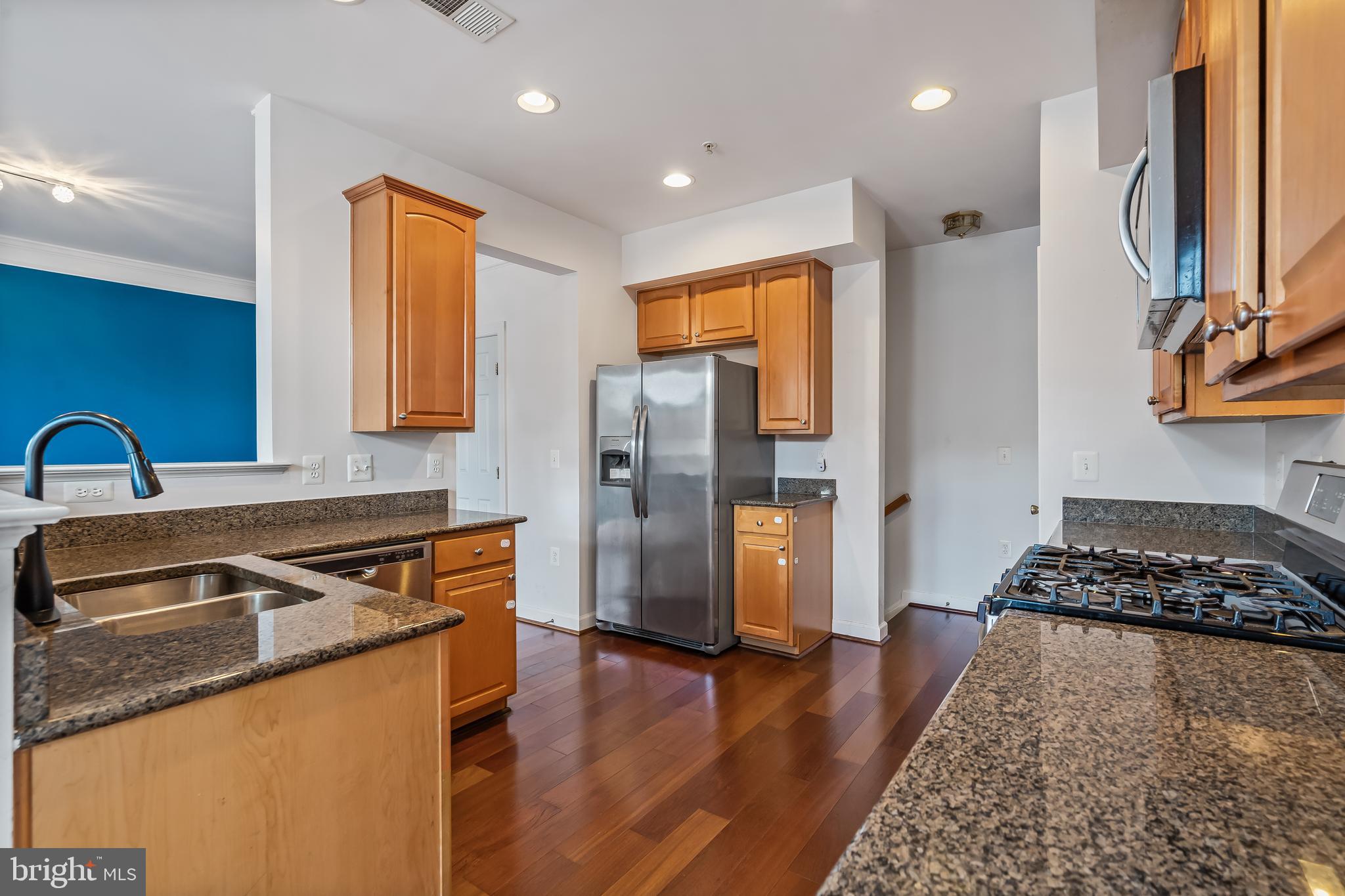 13600 Salk Street, Unit 131 Herndon, VA 20171 - Photo 6 of 34 a kitchen with stainless steel appliances granite countertop a sink stove and refrigerator