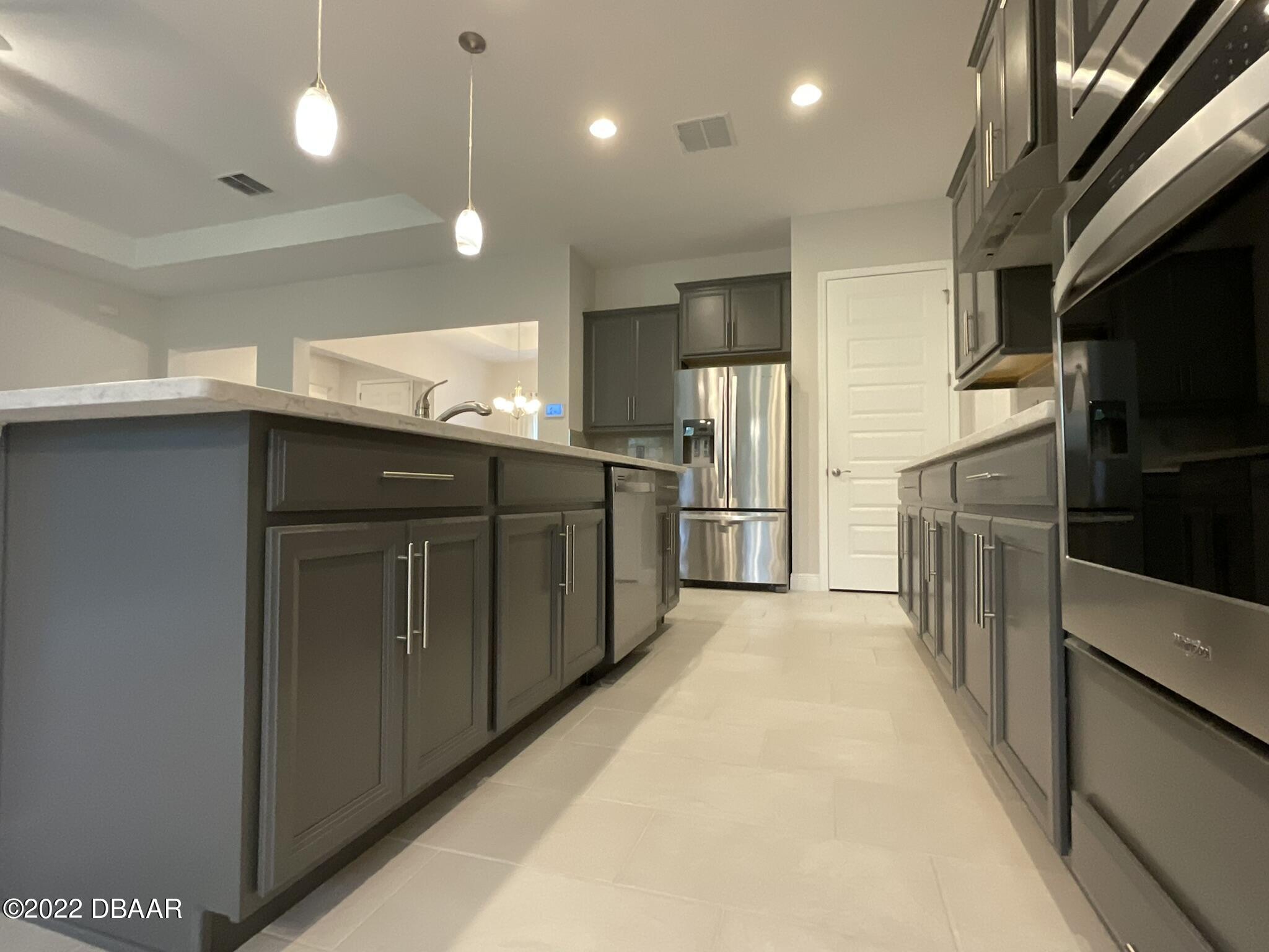 283 Cypress Trail Drive Ormond Beach, FL 32174 - Photo 6 of 28 a kitchen with stainless steel appliances kitchen island a refrigerator sink and stove