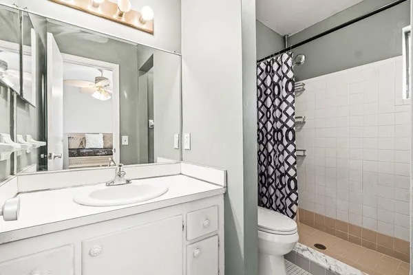 a bathroom with a sink a toilet and shower