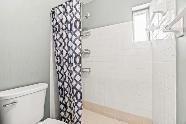 a bathroom with a toilet and a shower curtain