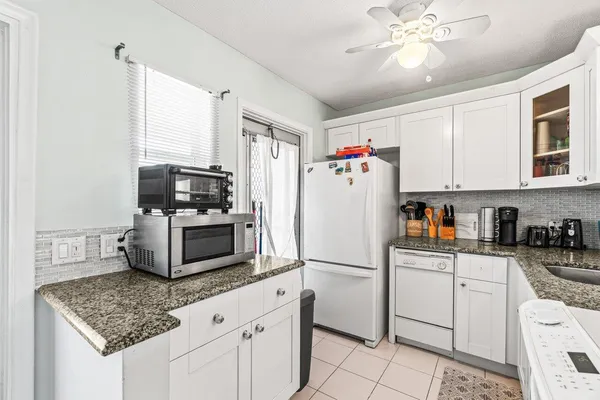 a kitchen with stainless steel appliances granite countertop a refrigerator sink and microwave