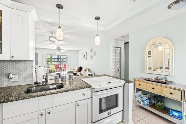 a kitchen with stainless steel appliances granite countertop a sink a stove and a wooden floors