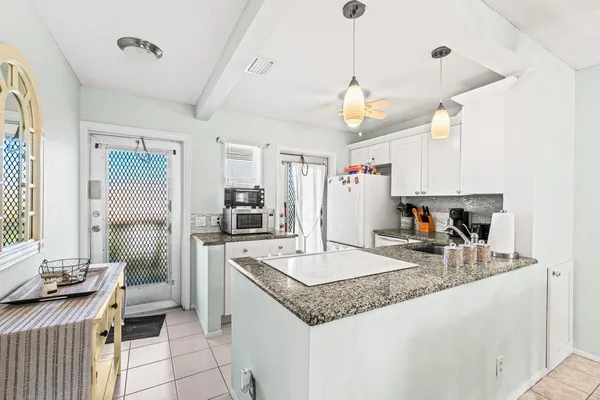a kitchen with sink refrigerator and microwave