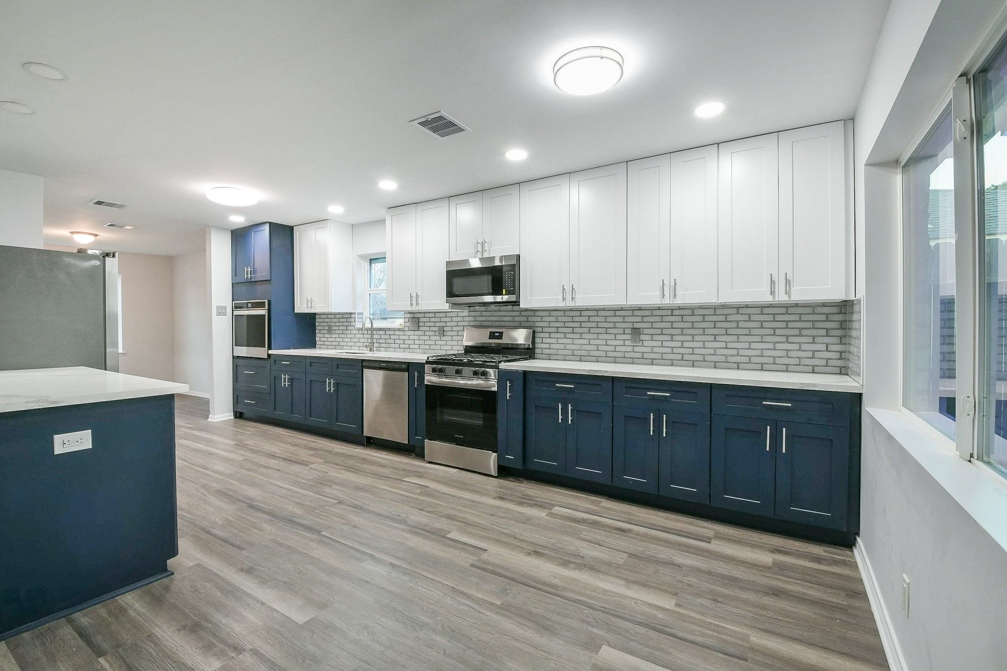 9111 Rentur Drive Houston, TX 77031 - Photo 5 of 21 a large kitchen with wooden floors stainless steel appliances and cabinets