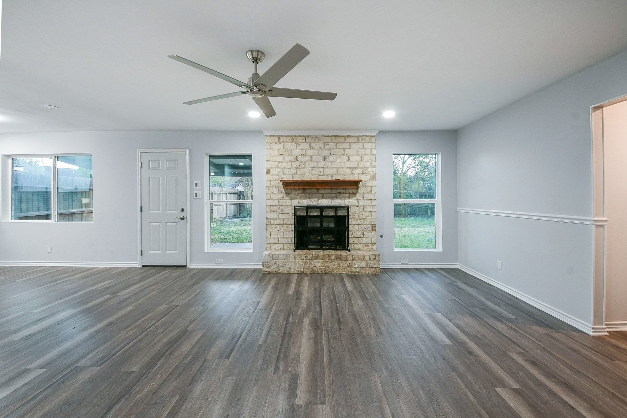 9111 Rentur Drive Houston, TX 77031 - Photo 9 of 21 an empty room with wooden floor fireplace cabinet and windows