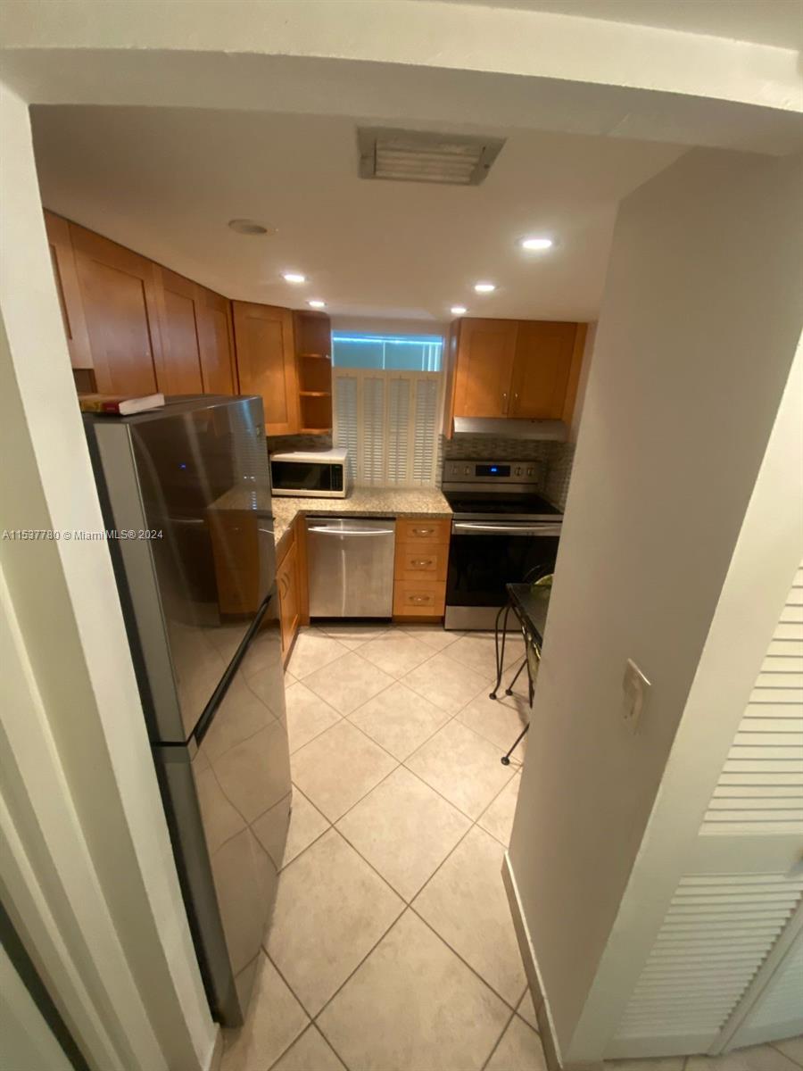 a kitchen with stainless steel appliances furniture and a refrigerator