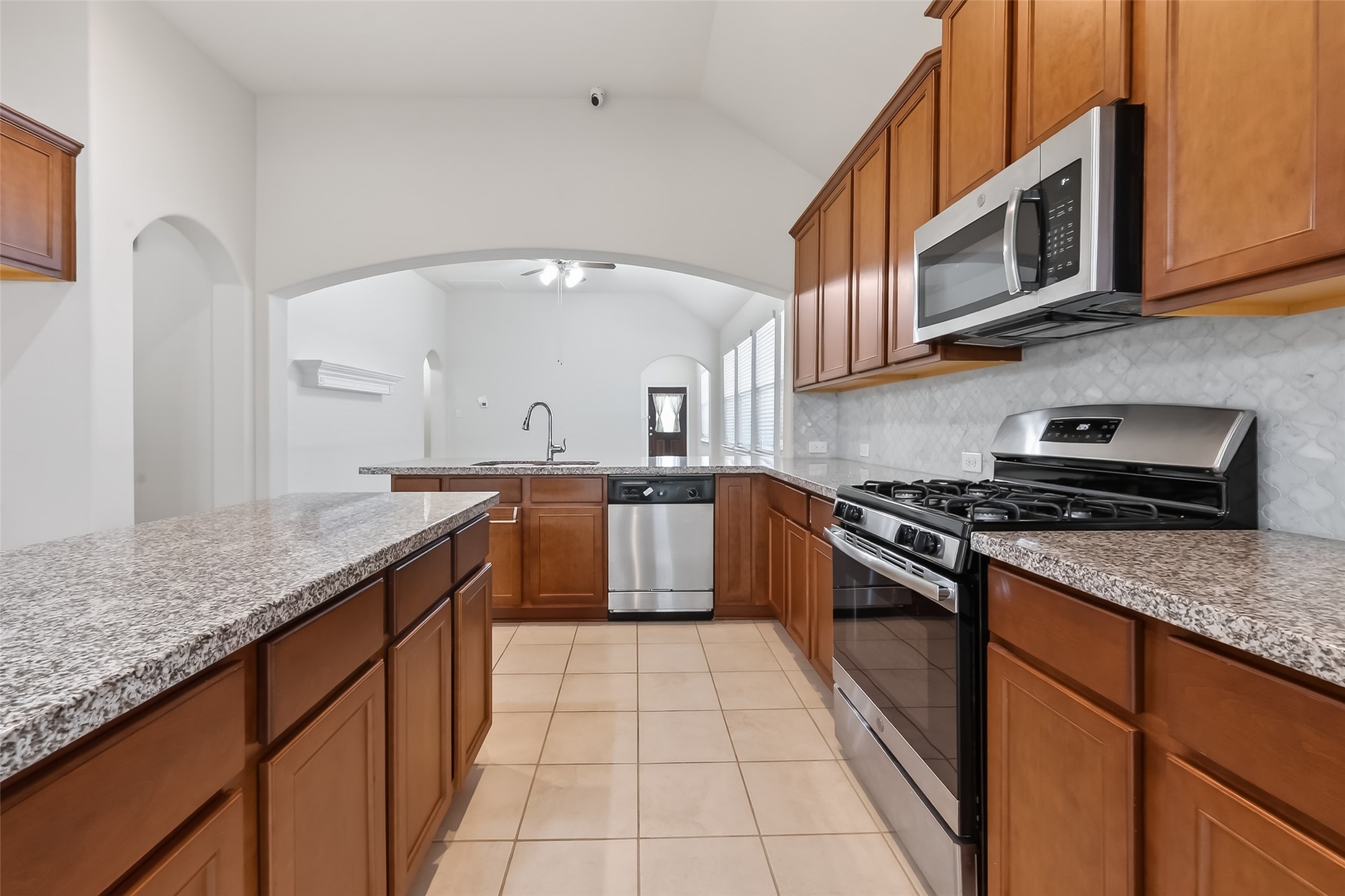 7631 Granite Terrace Lane Houston, TX 77083 - Photo 20 of 46 a kitchen with stainless steel appliances granite countertop a stove a sink and a microwave