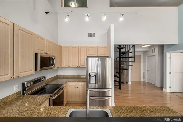 a kitchen with stainless steel appliances granite countertop a refrigerator and a stove top oven