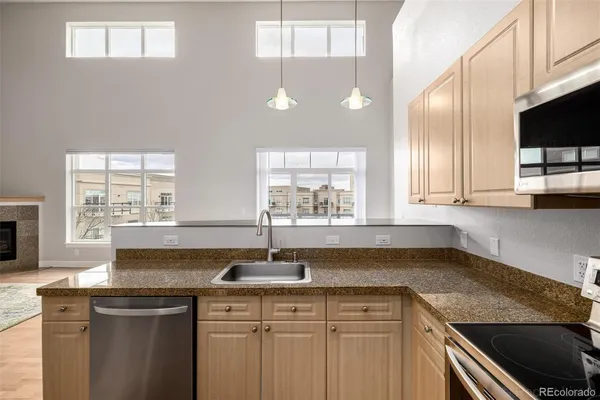 a kitchen with stainless steel appliances granite countertop a sink a stove and a granite counter tops with wooden floors