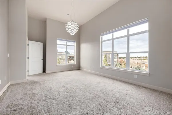 an empty room with a window and a chandelier