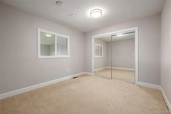 an empty room with a bathroom and a window