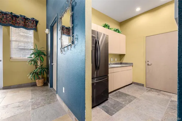 a view of a refrigerator in kitchen and an empty room