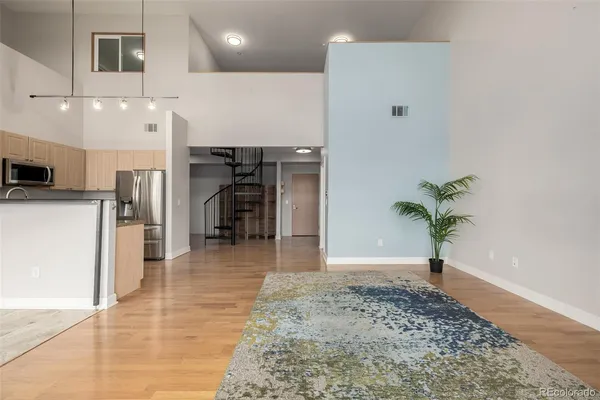 a view of a hallway with wooden floor and a potted plant