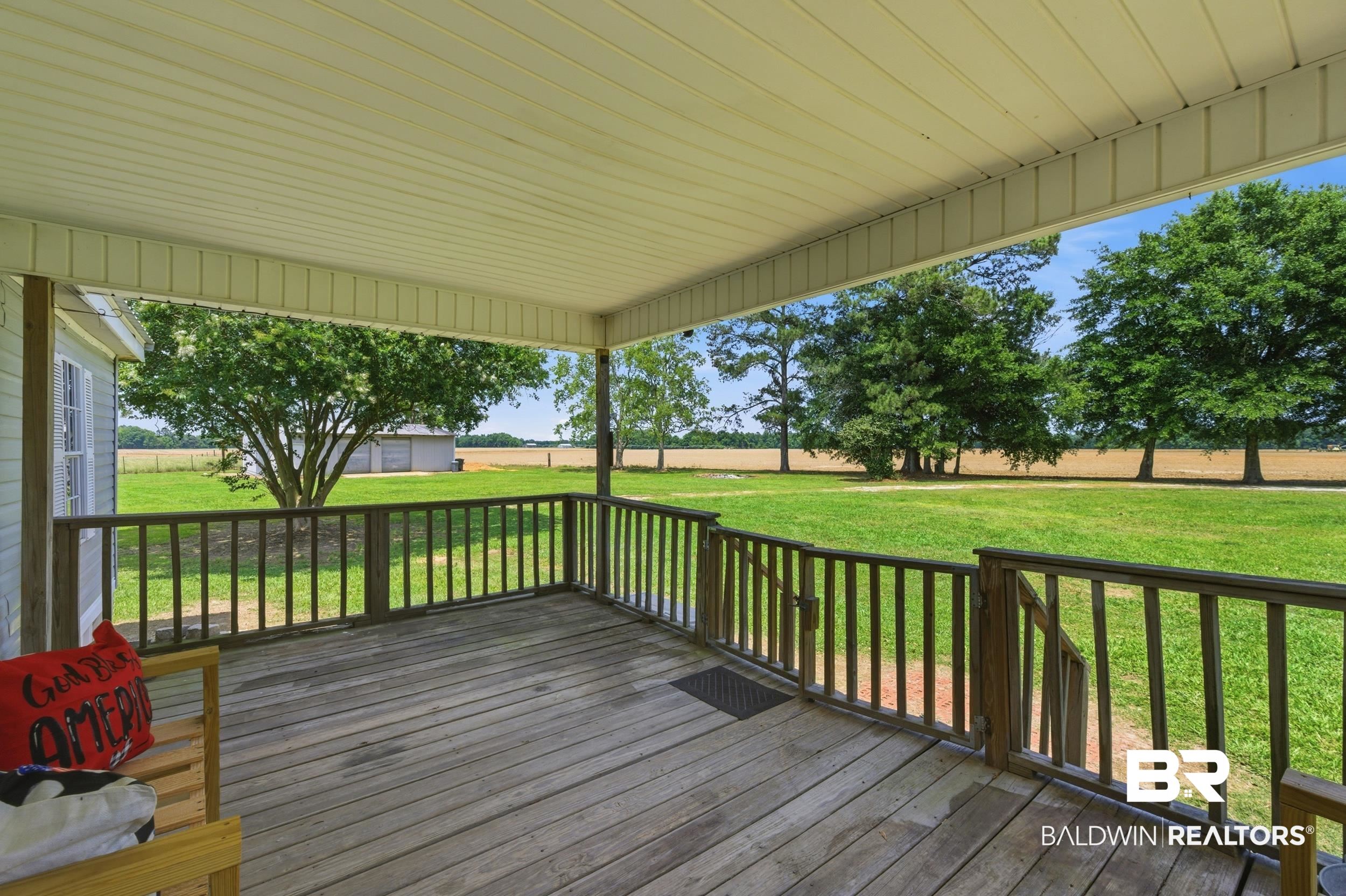 926 Tumbling Lane Atmore, AL 36502 - Photo 7 of 56 Expansive covered porch featuring wood flooring, wood railing, and a beadboard ceiling