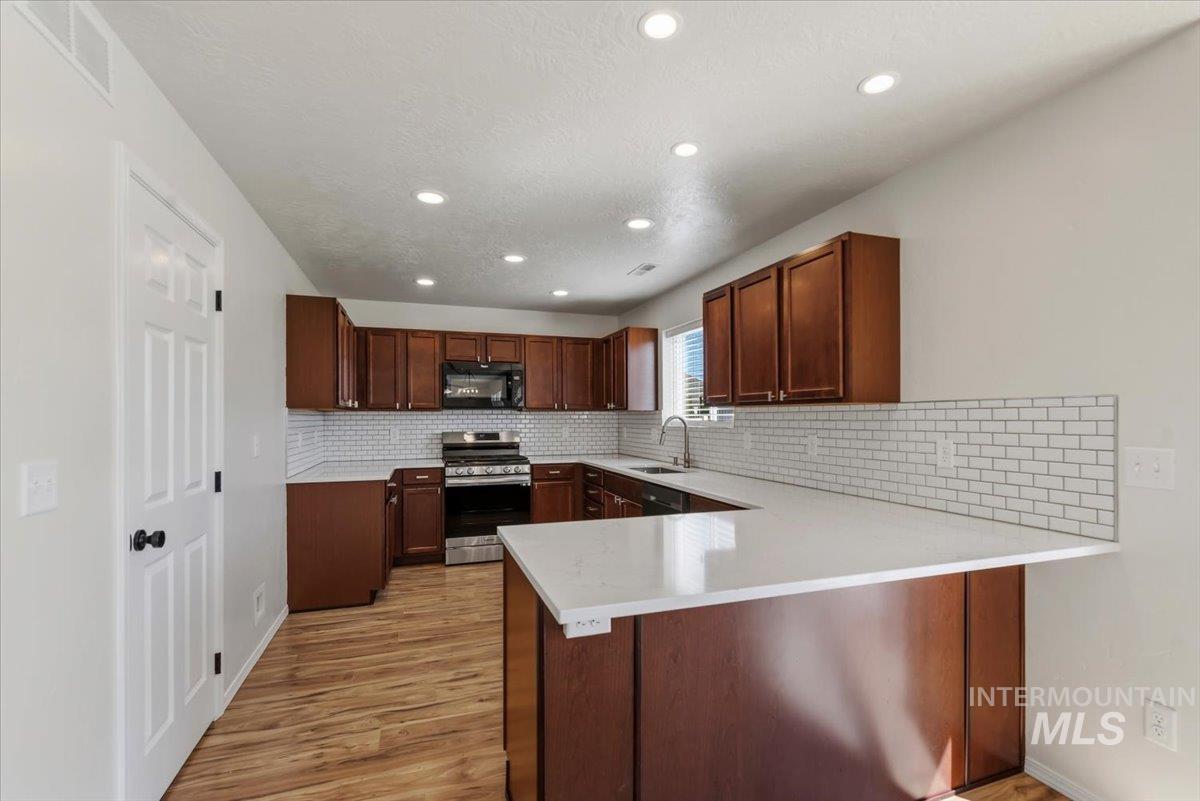 12310 West Hidden Point Drive Star, ID 83669 - Photo 10 of 48 Contemporary kitchen featuring LVP flooring and recessed lighting