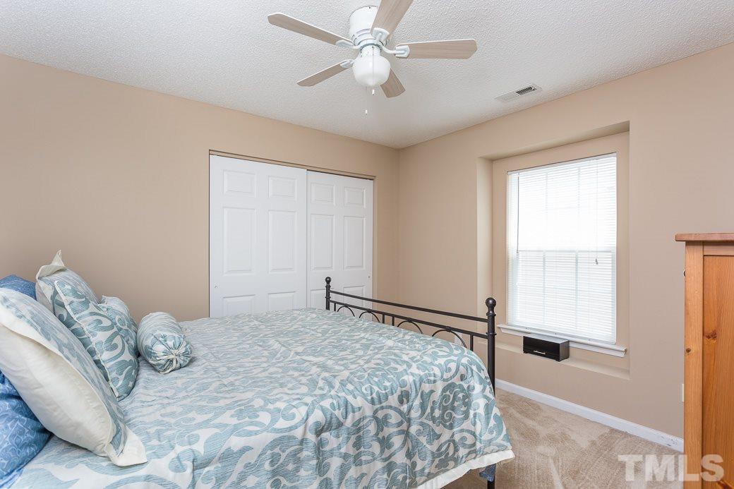 5716 Sea Fox Court Raleigh, NC 27616 - Photo 15 of 23 a bedroom with a large bed and a chandelier fan