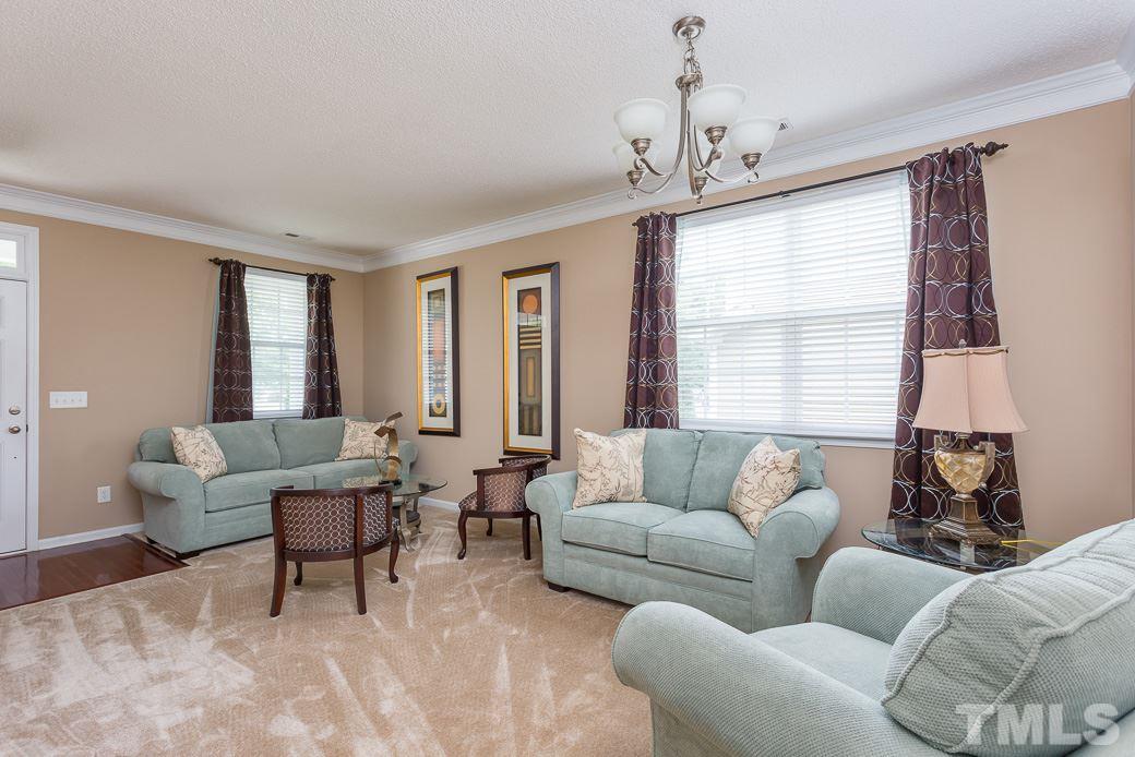 5716 Sea Fox Court Raleigh, NC 27616 - Photo 8 of 23 a living room with furniture and a chandelier