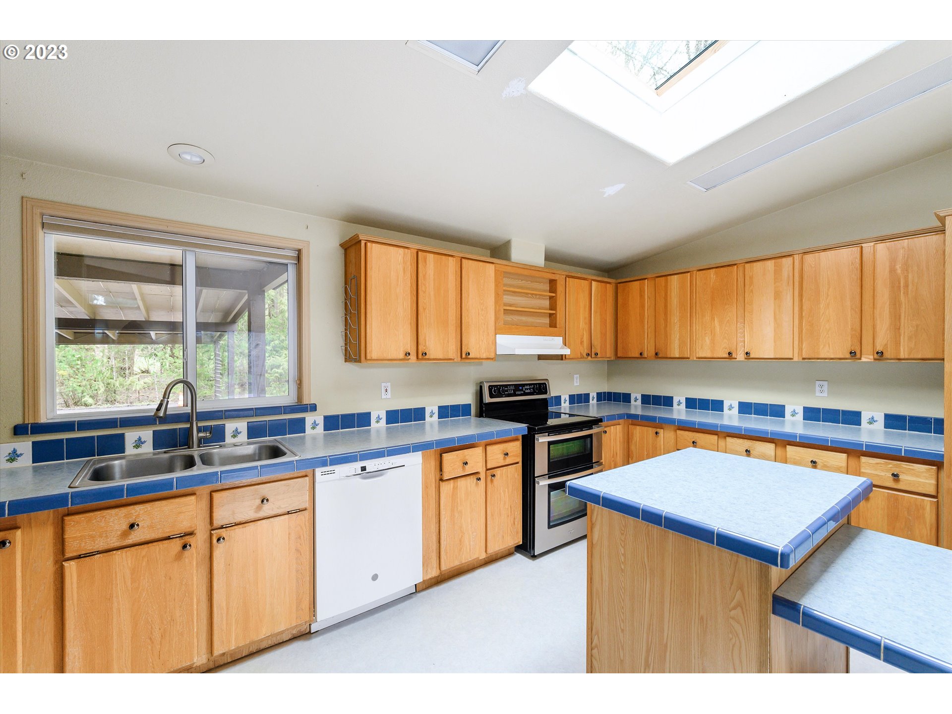 42264 Southeast Locksmith Lane Sandy, OR 97055 - Photo 11 of 36 a kitchen with stainless steel appliances granite countertop a sink a stove and a counter space