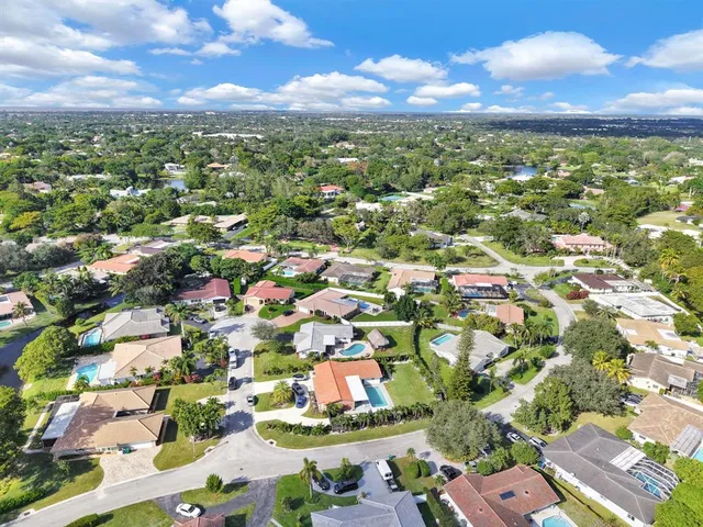 an aerial view of residential houses with outdoor space and street view