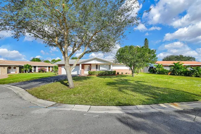a front view of a house with a yard and trees