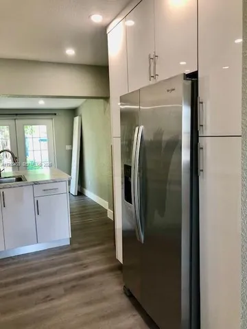 a kitchen with granite countertop white cabinets and white appliances