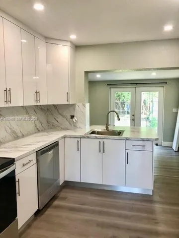 a kitchen with stainless steel appliances a stove a microwave and sink