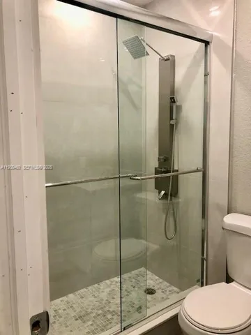 a bathroom with a toilet and a shower