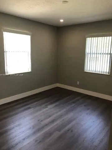 an empty room with wooden floor and closet