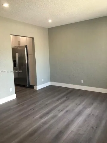 a kitchen with stainless steel appliances a refrigerator and wooden floor