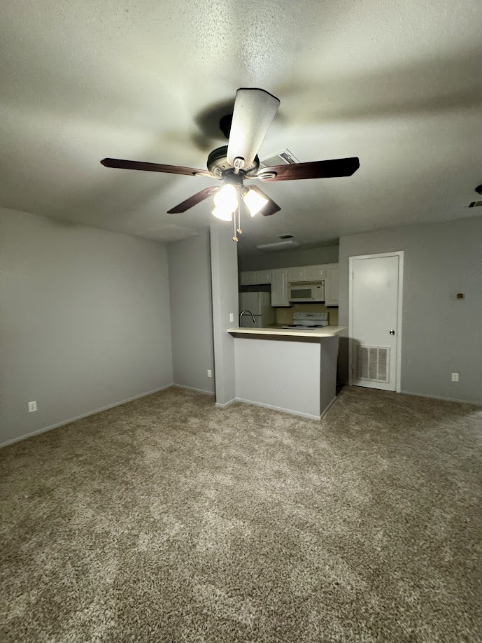 1305 West Villa Maria Road, Unit C107 Bryan, TX 77801 - Photo 6 of 19 Unfurnished living room featuring carpet flooring and baseboards