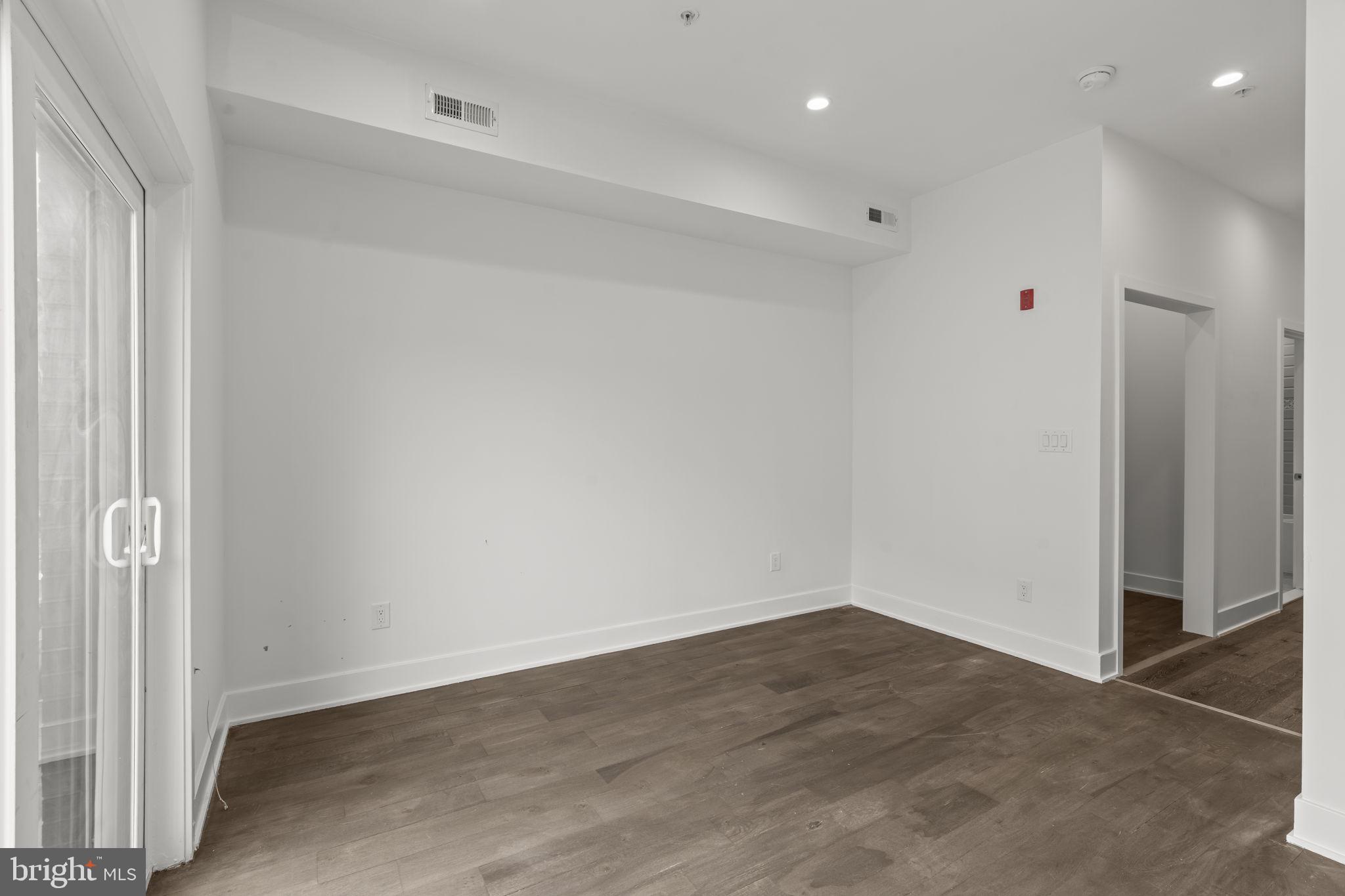 1244 South 20th Street, Unit 2 Philadelphia, PA 19146 - Photo 16 of 28 an empty room with wooden floor and windows