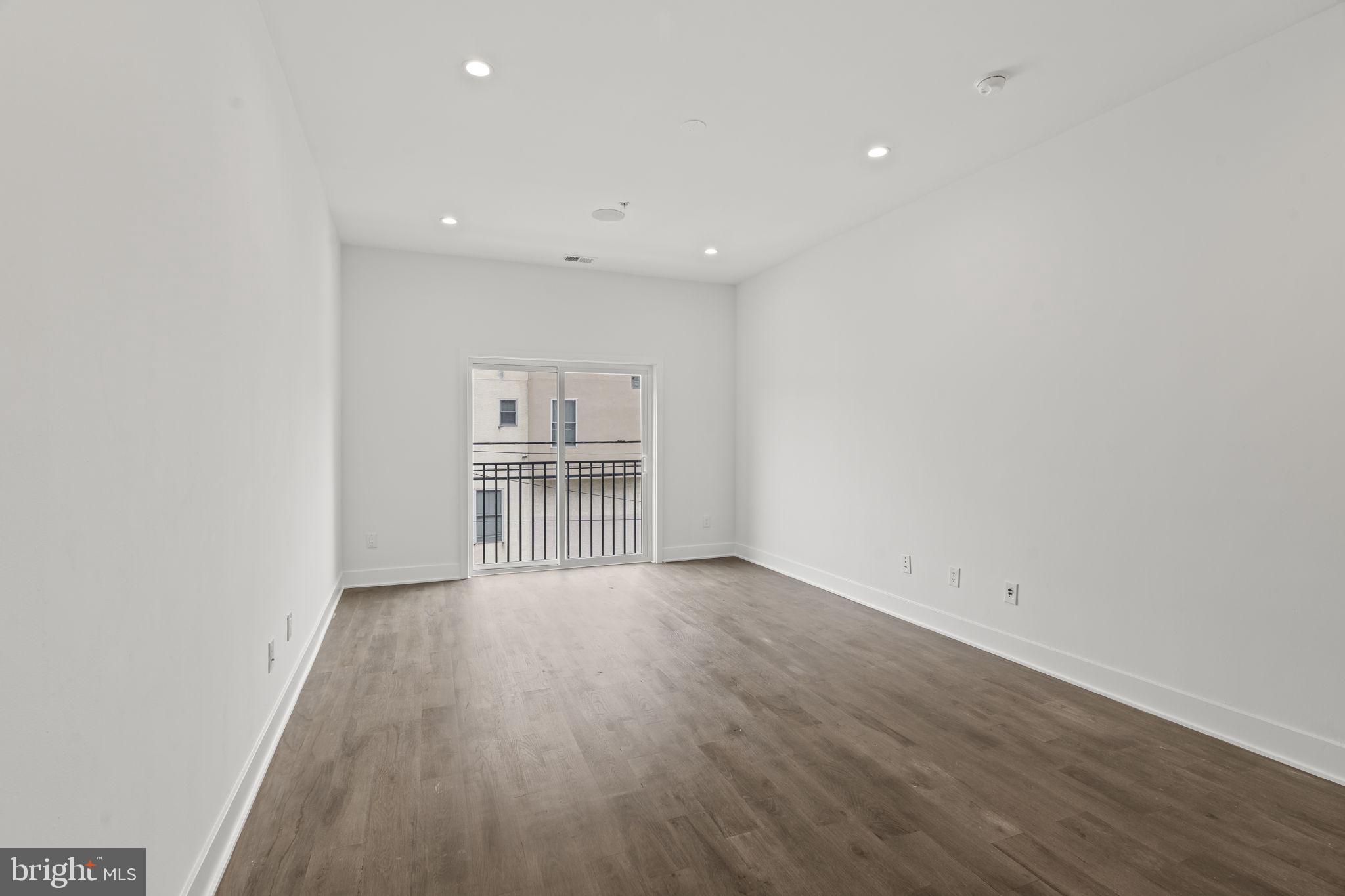 1244 South 20th Street, Unit 2 Philadelphia, PA 19146 - Photo 5 of 28 an empty room with wooden floor and windows