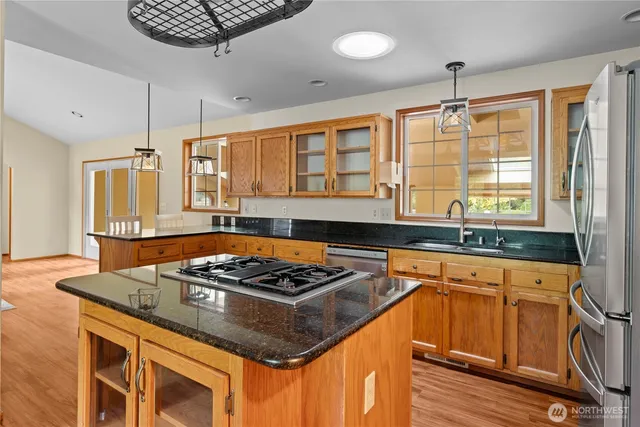 a kitchen with stainless steel appliances granite countertop a stove a sink and a refrigerator