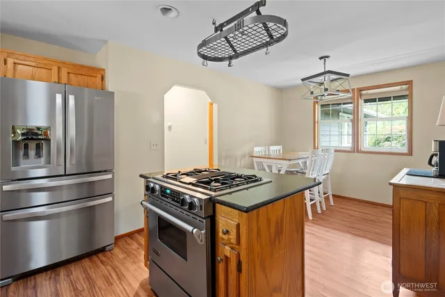 a kitchen with stainless steel appliances granite countertop a stove a refrigerator and a dining table