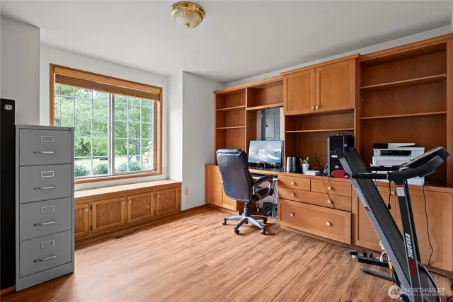 a view of a workspace with furniture and a window