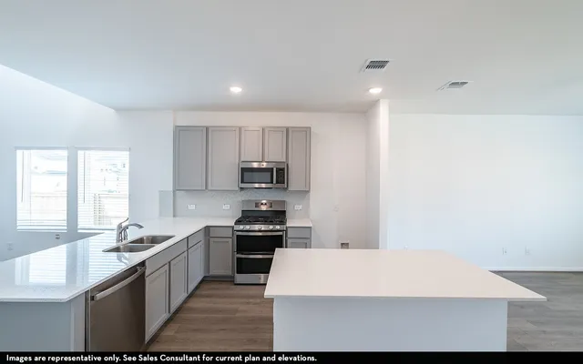 a large white kitchen with stainless steel appliances