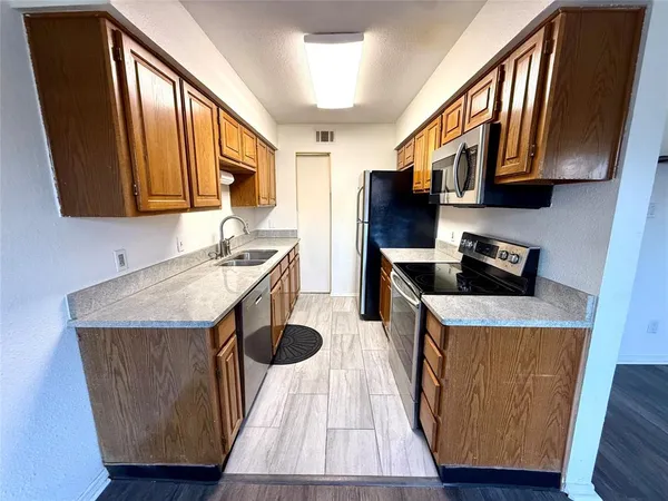 a kitchen with stainless steel appliances granite countertop a sink stove and refrigerator