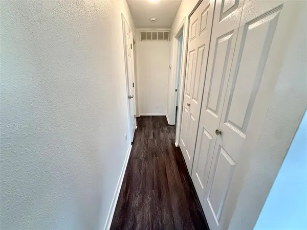 a view of a hallway with wooden floor and staircase