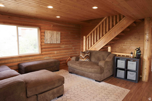 15253 Mill Road, Unit 62 Huntsville, UT 84317 - Photo 15 of 48 Wood-paneled interior featuring a prominent staircase with wood balusters, a large window, recessed ceiling lighting, and wood-finish flooring