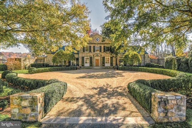 an aerial view of a residential houses with outdoor space and trees all around