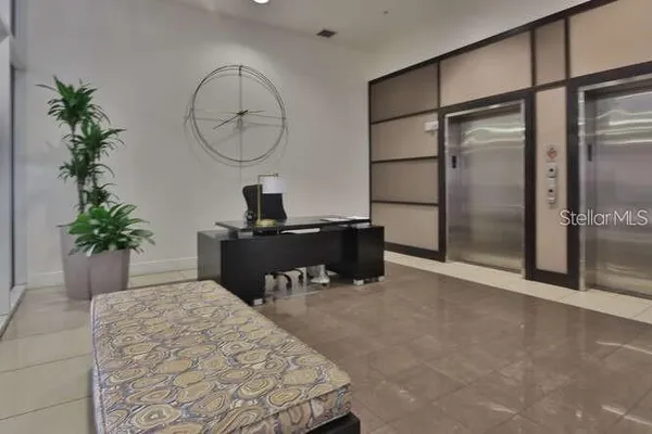 a room with a potted plant and a large mirror on a dresser