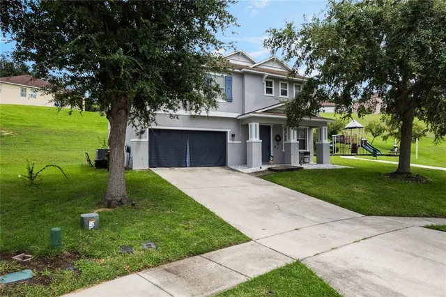 a front view of a house with a yard and trees