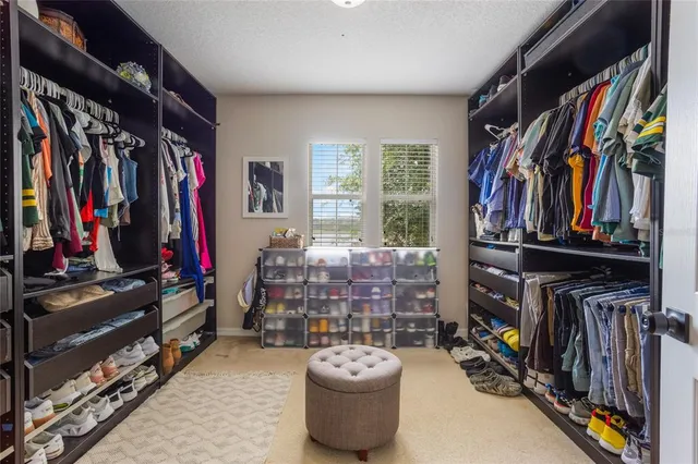 a view of walk in closet with clothes