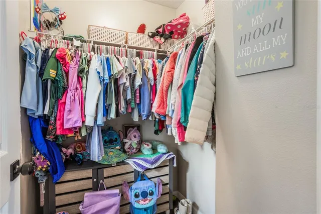 a view of walk in closet with clothes and shoes