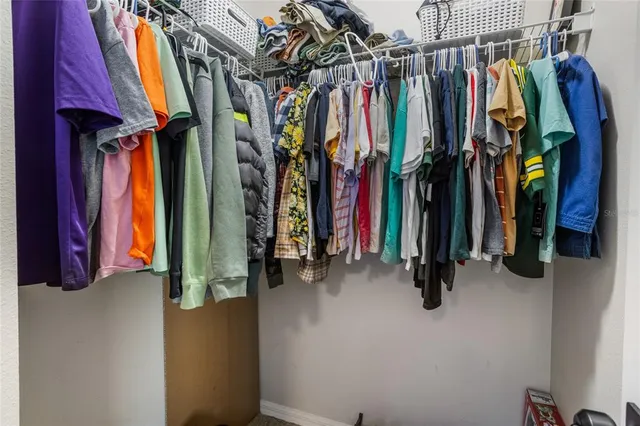 a view of walk in closet with clothes and shoes