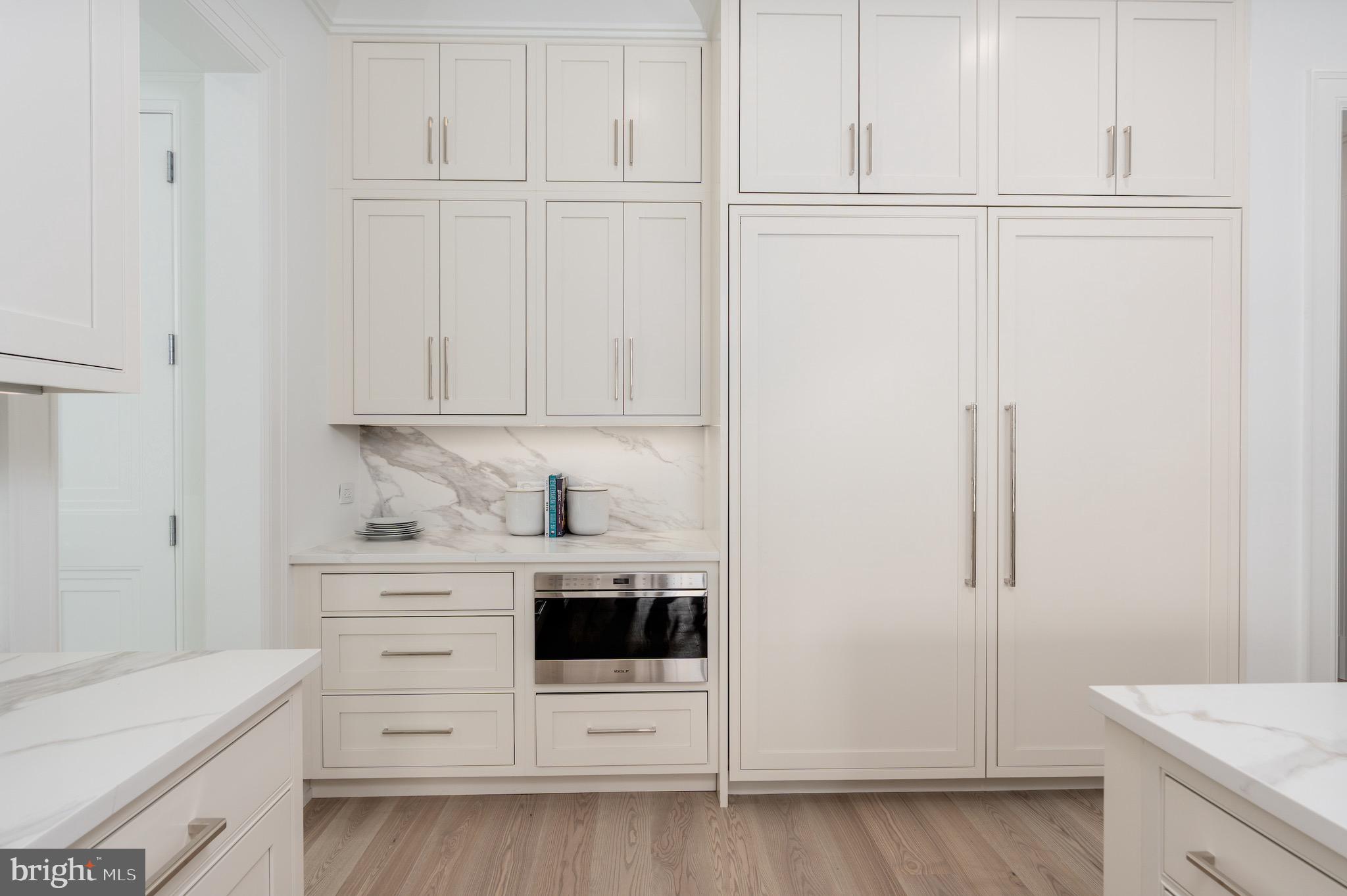 4821 Rodman Street Northwest Washington, DC 20016 - Photo 17 of 52 a kitchen with white cabinets and white appliances